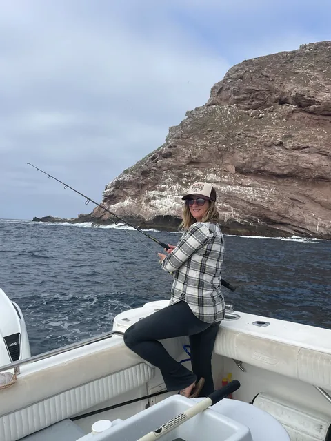 Angler casting toward the island cliffs from the boat.